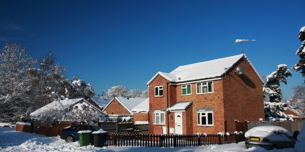 Detached house in snow with blue sky